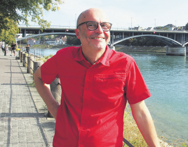 Wendel Hilti vor dem Rhein in Basel: Der Fluss ist für ihn das Symbol der trinationalen Zusammenarbeit in der Region, die der Gipf-Oberfricker sehr schätzt. Über die Wettsteinbrücke im Hintergrund führt am Sonntag der slowUp, den Hilti mit seiner Frau organisiert. Foto: Boris Burkhardt